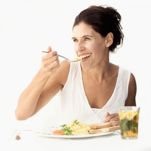 Woman eating scrambled eggs with a fork