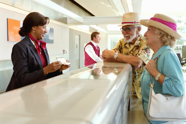 safe travels with diabetes: Picture of senior couple checking in at airport terminal